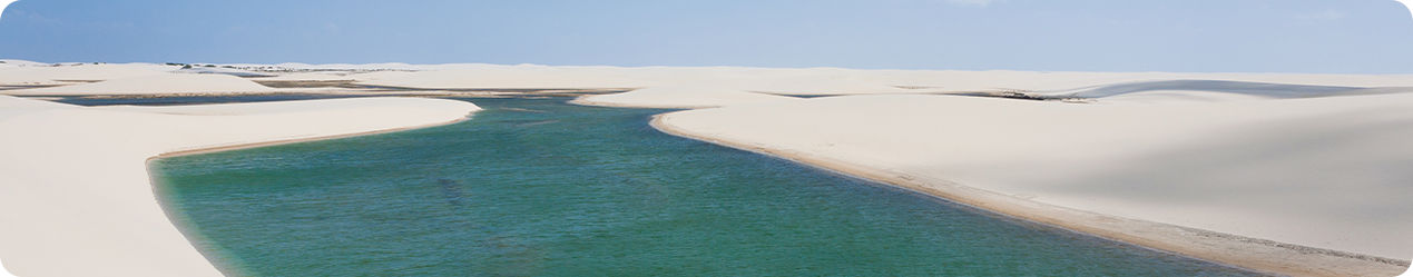 paisagem de uma lagoa azul em meio a dunas de areia branca